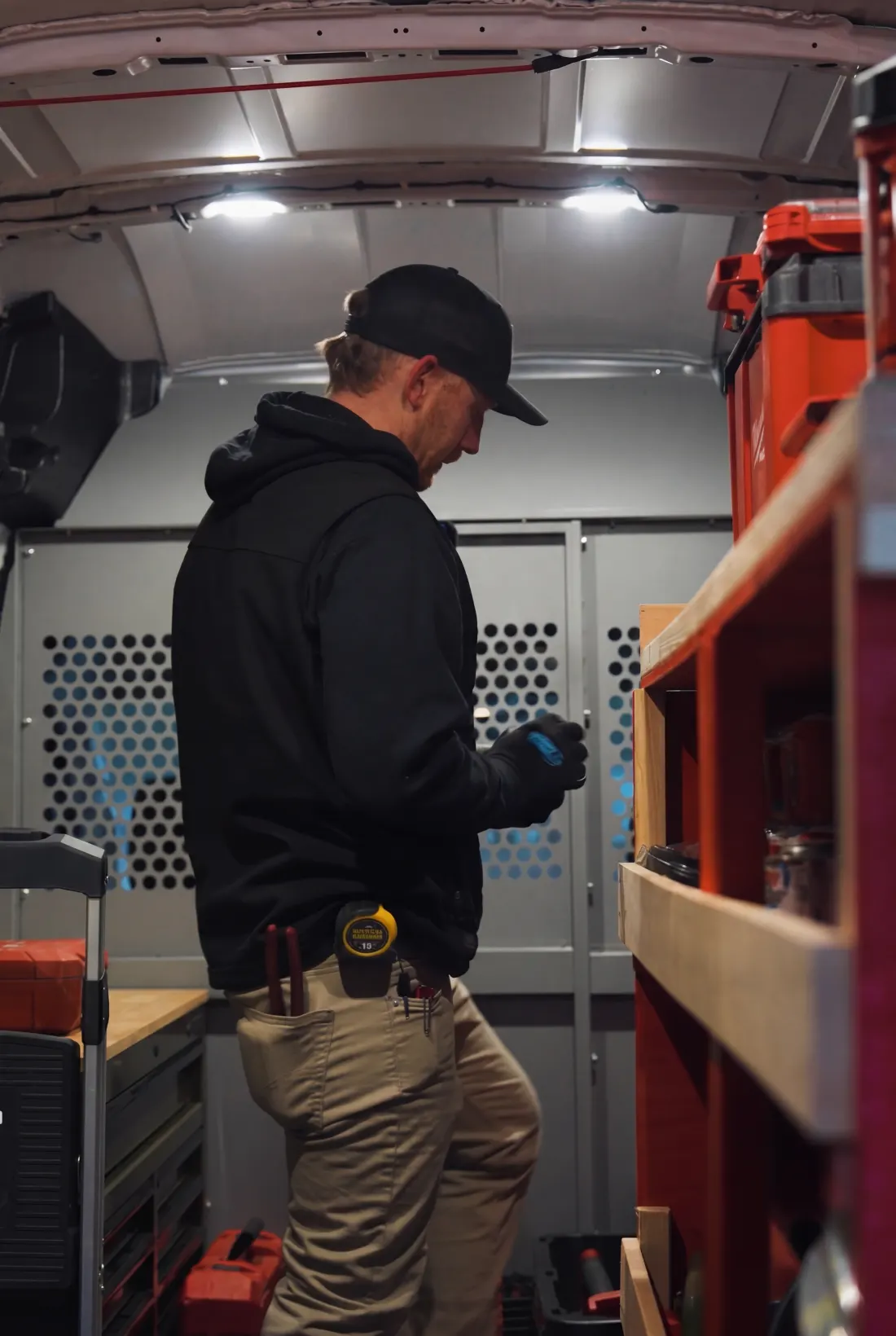 Valor Plumbing plumber pulling parts from the shelves of a stocked service van