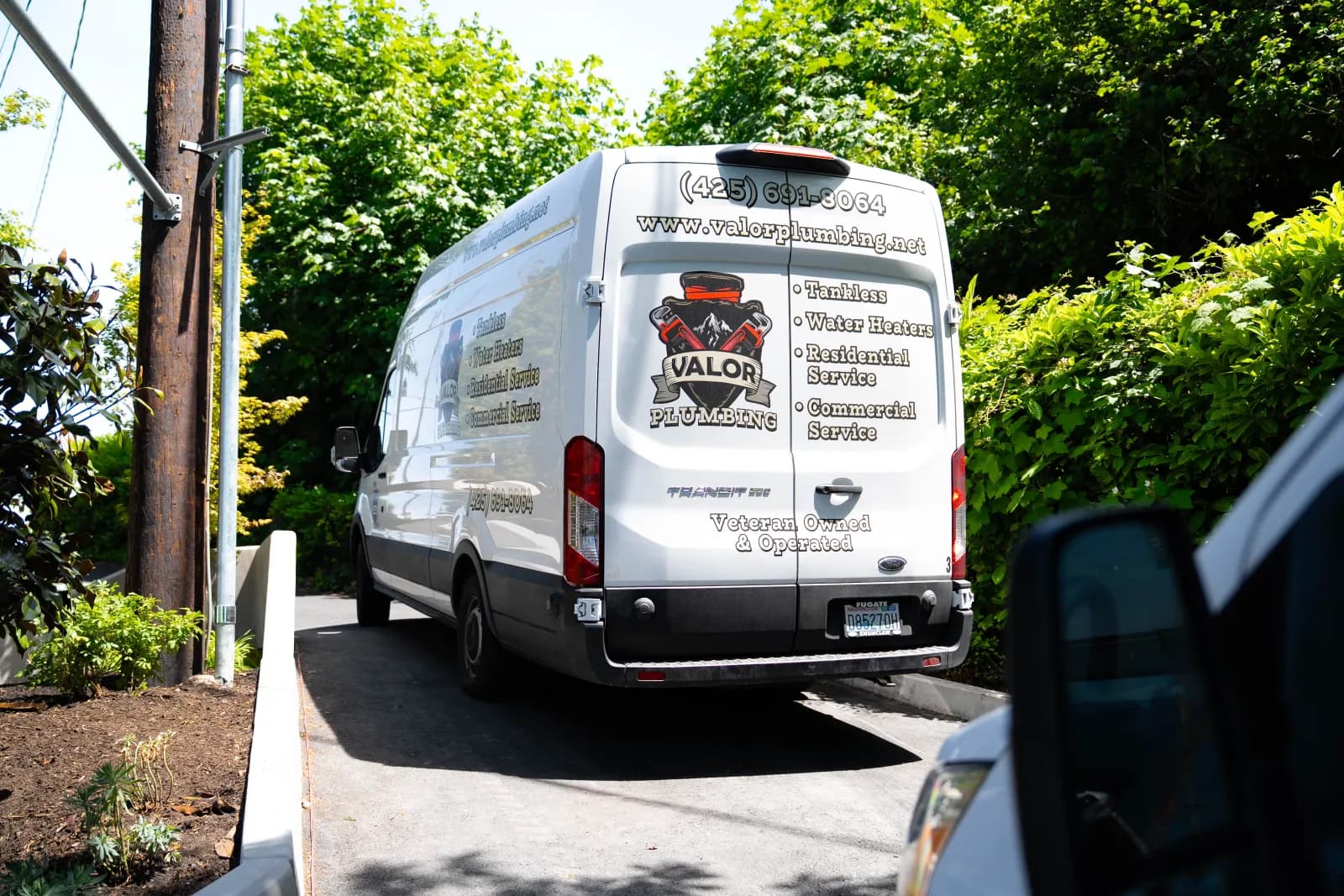 Valor Plumbing service van parked in a residential driveway